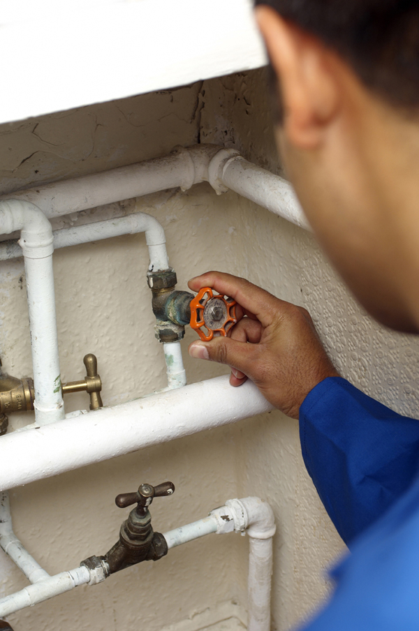 Berkeley Plumbing associate adjusts gate valve